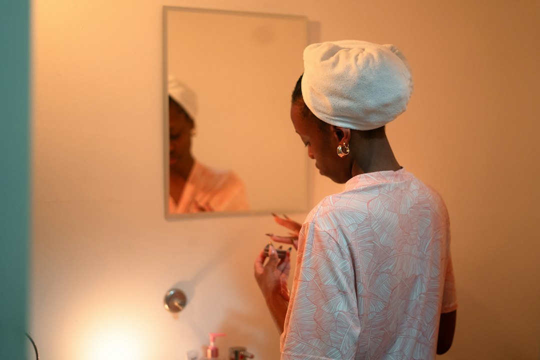 Woman applying makeup in front of a mirror