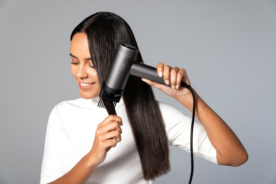 a woman blow drying her hair with a hair dryer